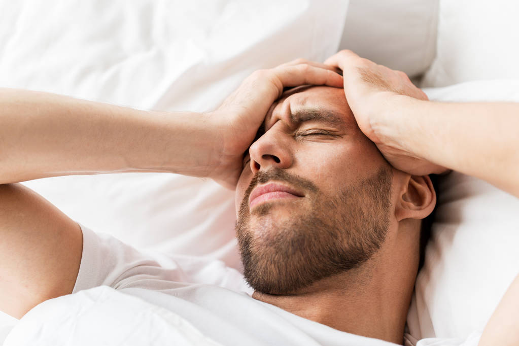 close up of man in bed suffering from headache - Photo, Image