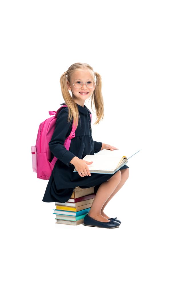 schoolmeisje zittend op stapel boeken - Foto, afbeelding