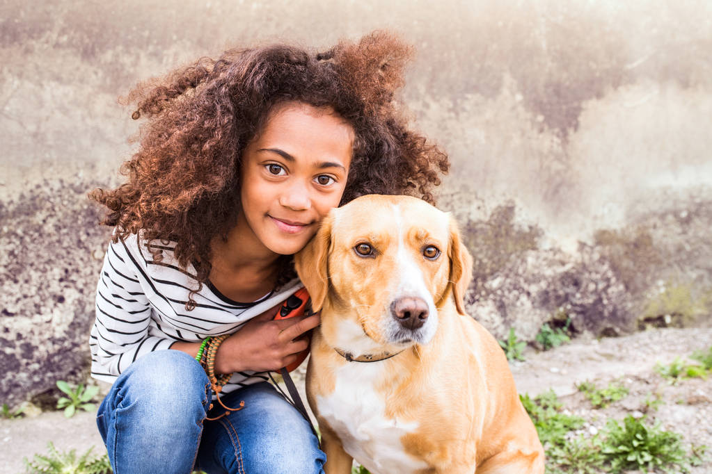 Afro-americano ragazza con il suo cane contro muro di cemento
. - Foto, immagini
