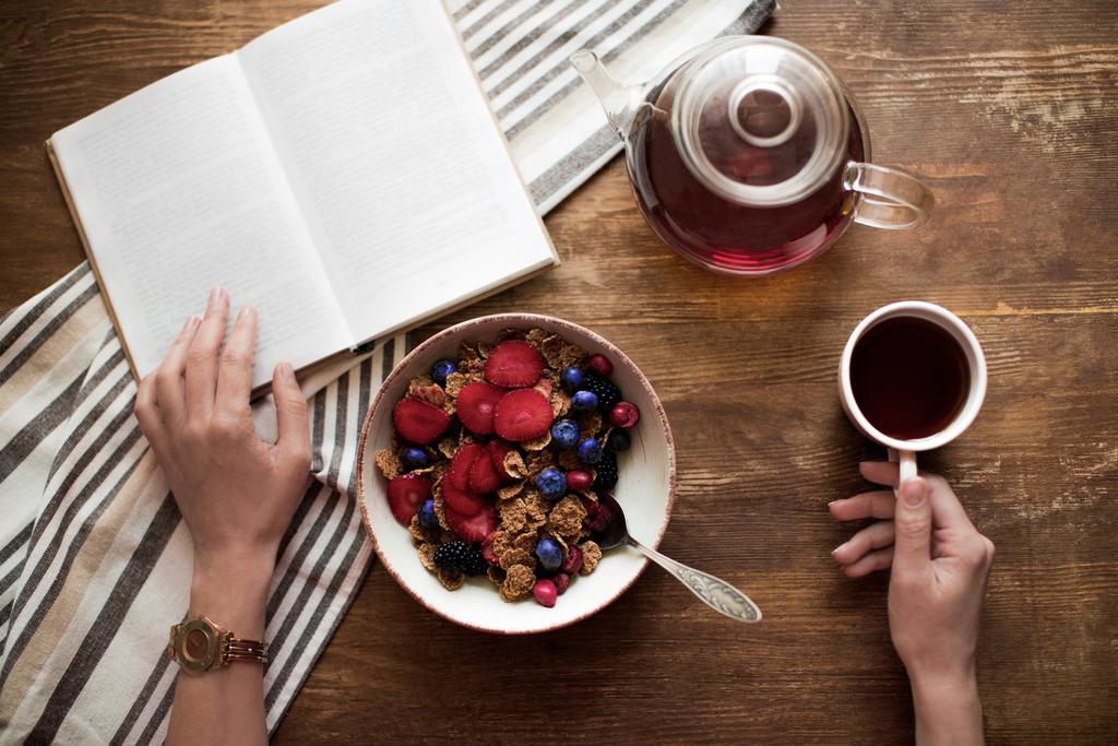 vrouw leesboek tijdens het ontbijt - Foto, afbeelding