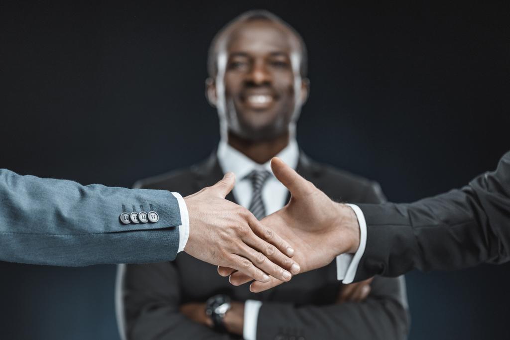 Партнеры по многонациональному бизнесу пожимают руки
 - Фото, изображение