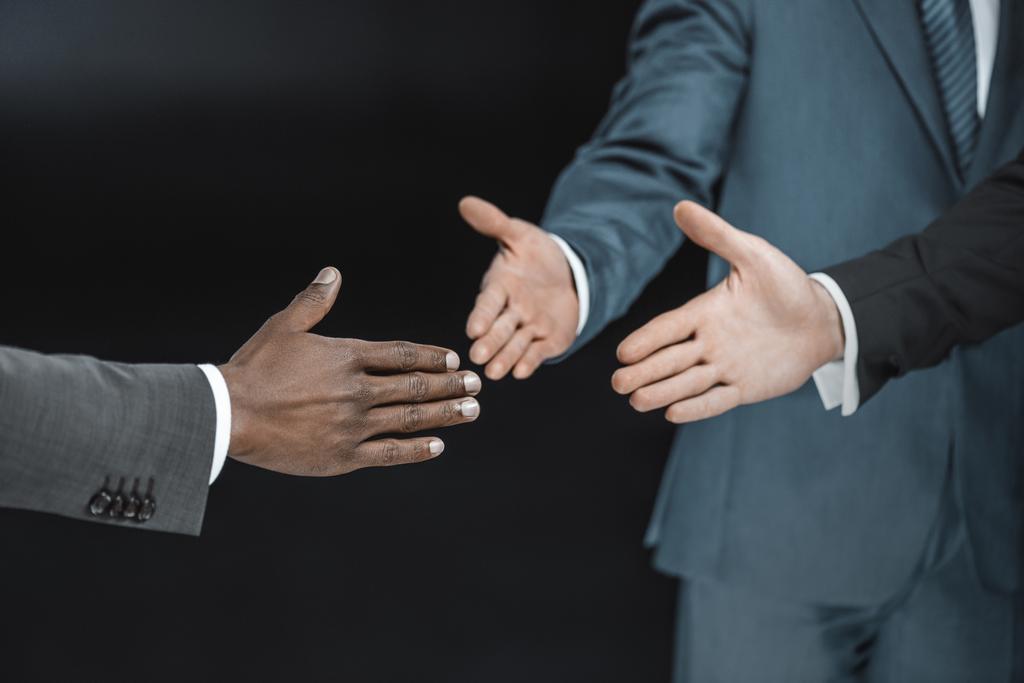 hombres de negocios multiétnicos extendiendo las manos
 - Foto, Imagen