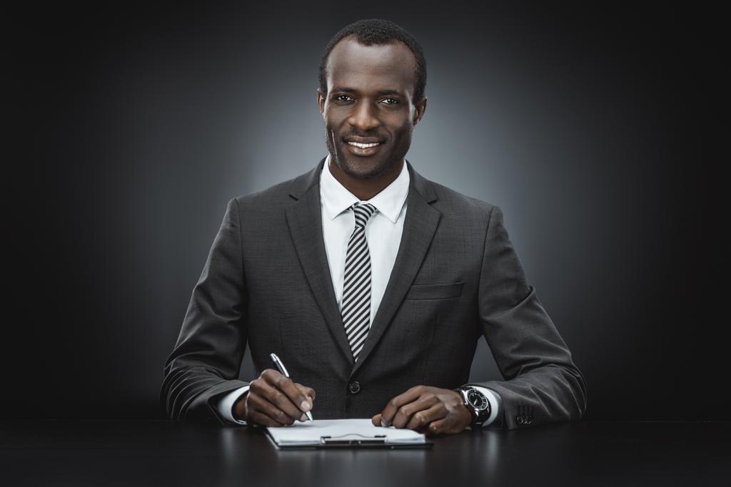 Afro-Amerikaanse zakenman doen papierwerk - Foto, afbeelding