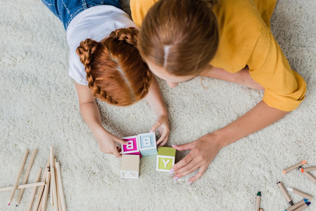 mãe e filha brincando com cubos de carta
 - Foto, Imagem