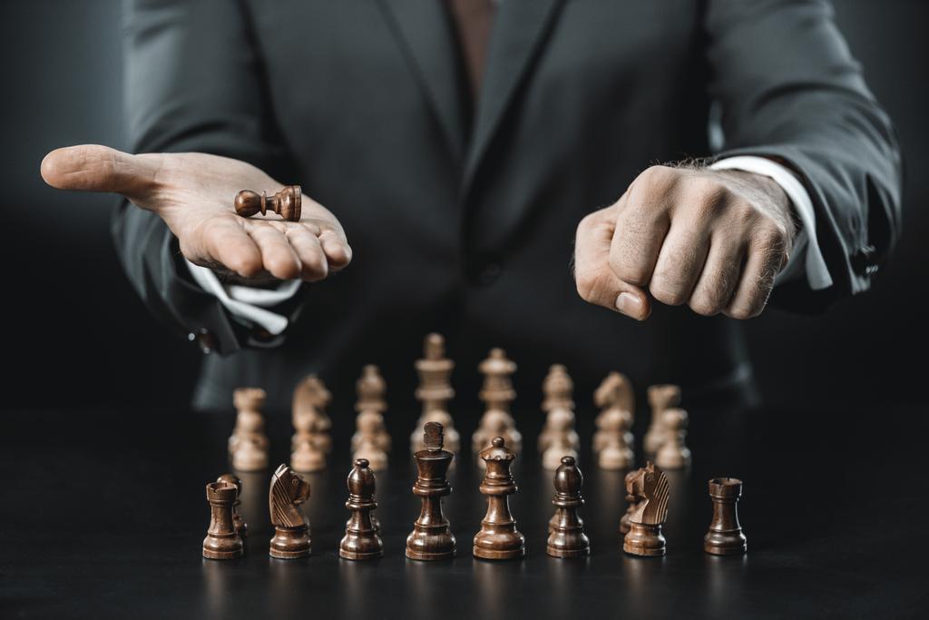 figuras de hombre de negocios y ajedrez en la mesa
 - Foto, Imagen