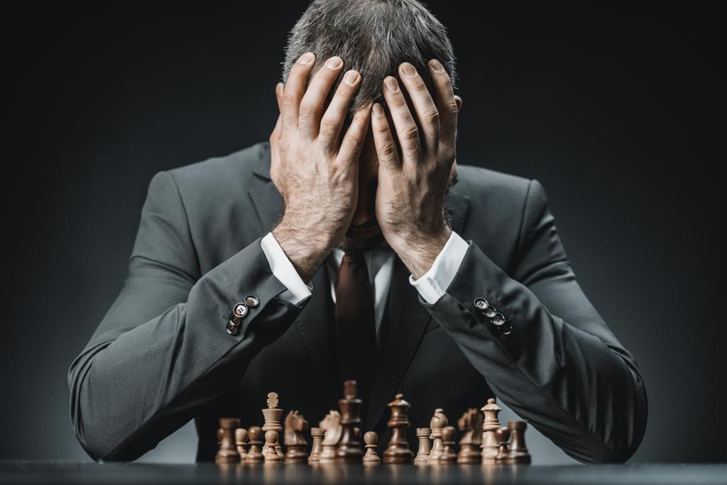 hombre de negocios sentado en la mesa con piezas de ajedrez
 - Foto, imagen