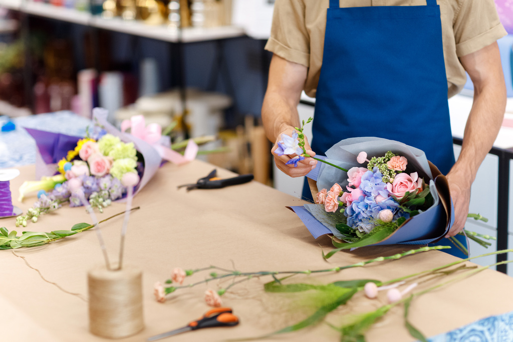 Флорист работает в цветочном магазине - Фото, изображение