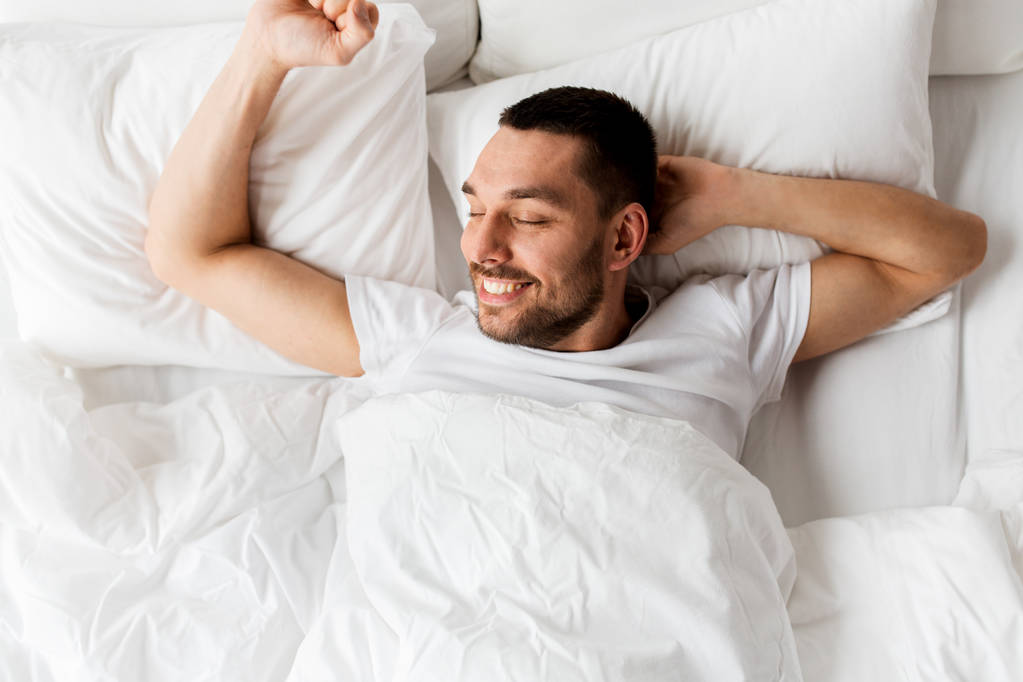 Hombre acostado en la cama en casa
 - Foto, imagen