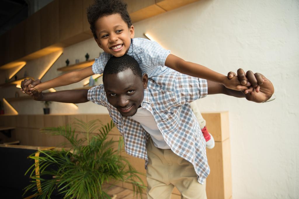 afro-amerikai apa piggybacking fiú - Fotó, kép