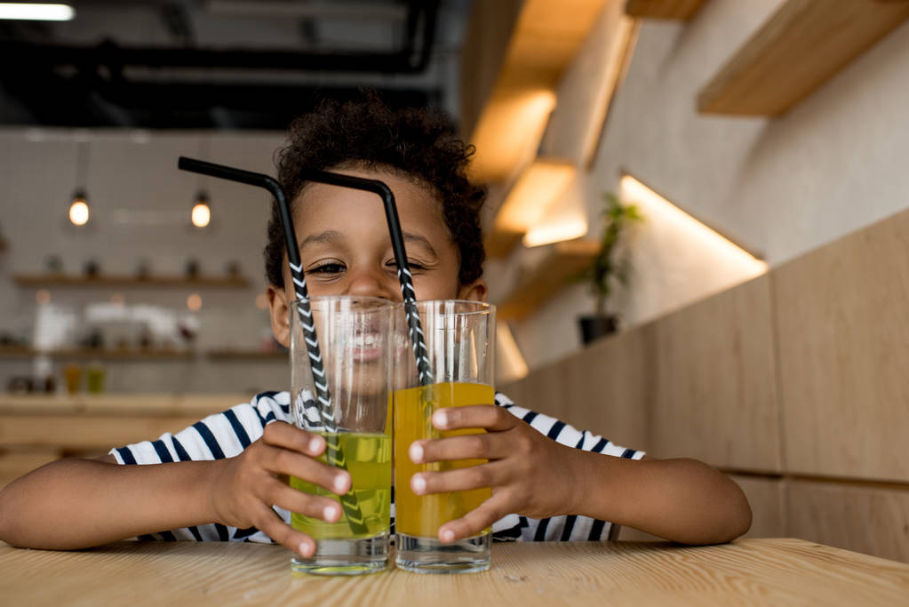 ジュースのグラスとアフリカ系アメリカ人の子  - 写真・画像