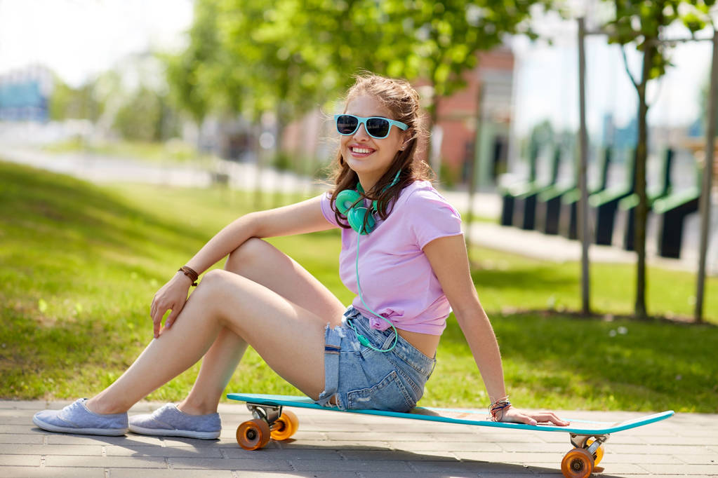ευτυχισμένος κορίτσι εφηβικής με ακουστικά και longboard - Φωτογραφία, εικόνα