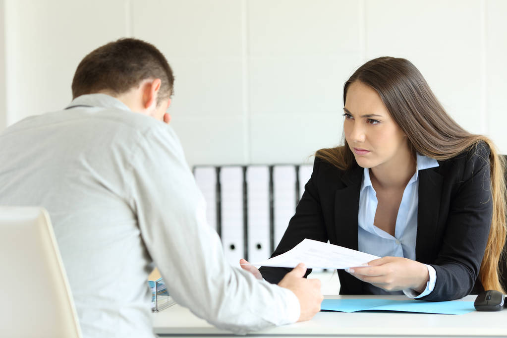 Angry boss giving document to a sad employee - Photo, Image