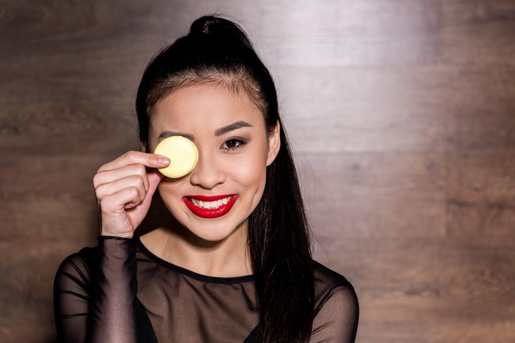Aziatische vrouw met macaron  - Foto, afbeelding