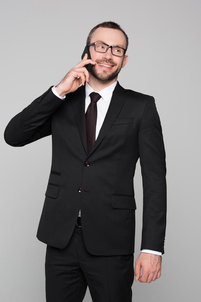 Улыбающийся молодой бизнесмен разговаривает по телефону
  - Фото, изображение