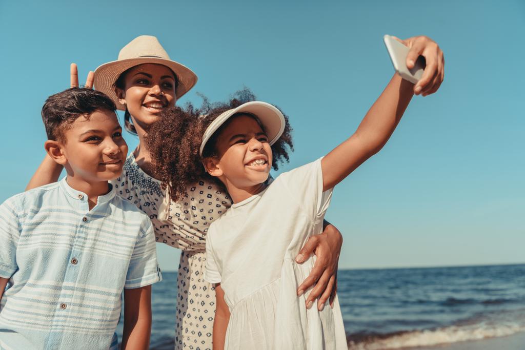 mother with kids taking selfie on beach - Photo, Image