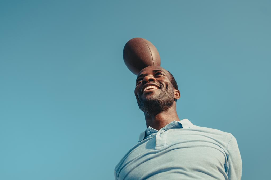 hombre afroamericano con pelota de rugby
 - Foto, Imagen