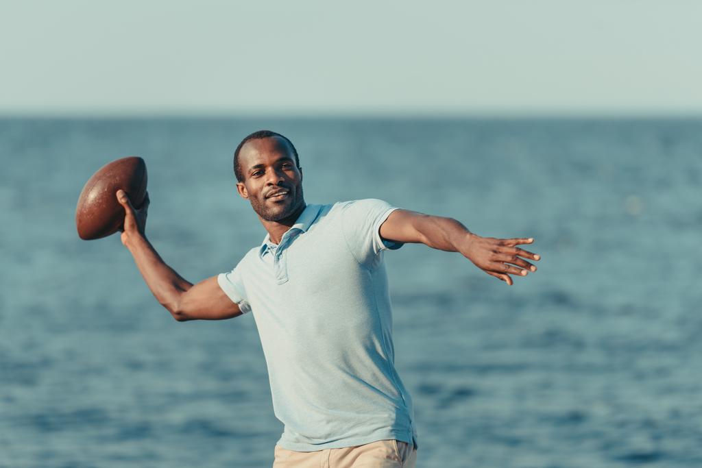 афроамериканський чоловік з м'ячем регбі
 - Фото, зображення