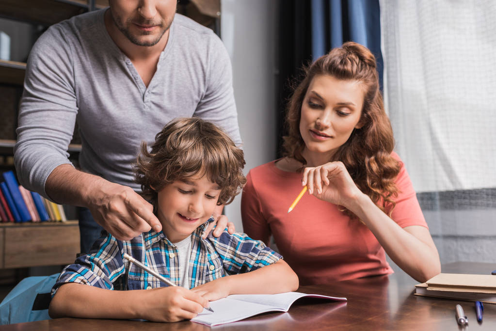 Parents aidant fils avec les devoirs
 - Photo, image