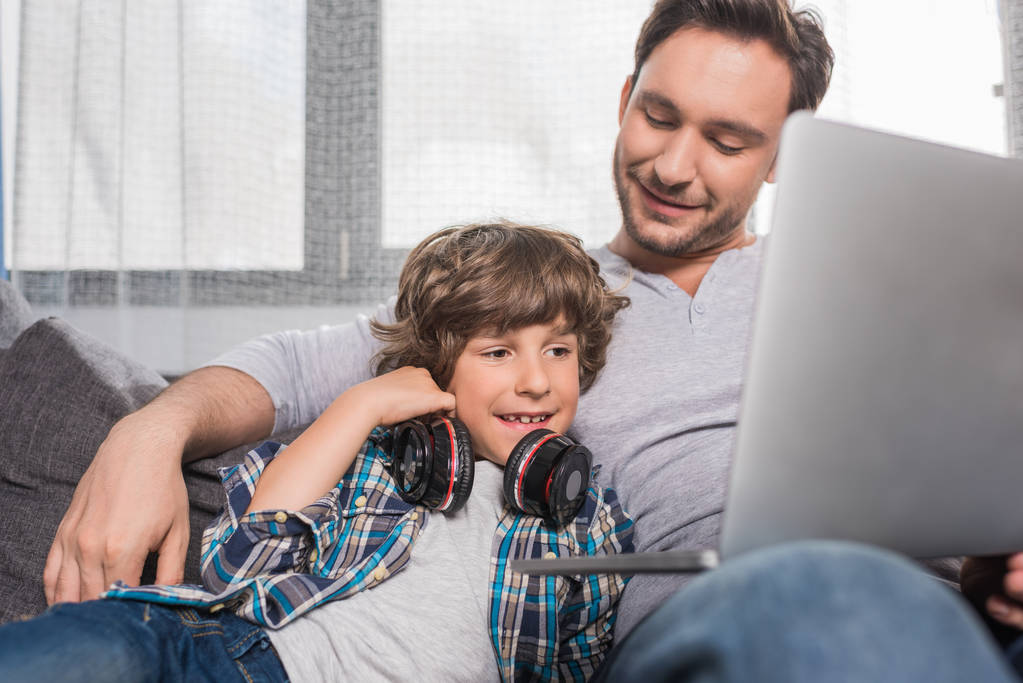 Isä ja poika kannettavalla tietokoneella
 - Valokuva, kuva