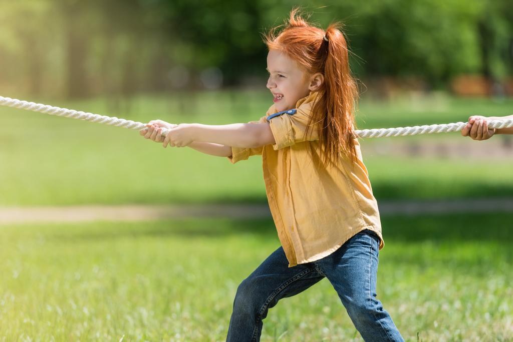 rothaariges Kind zieht Seil - Foto, Bild