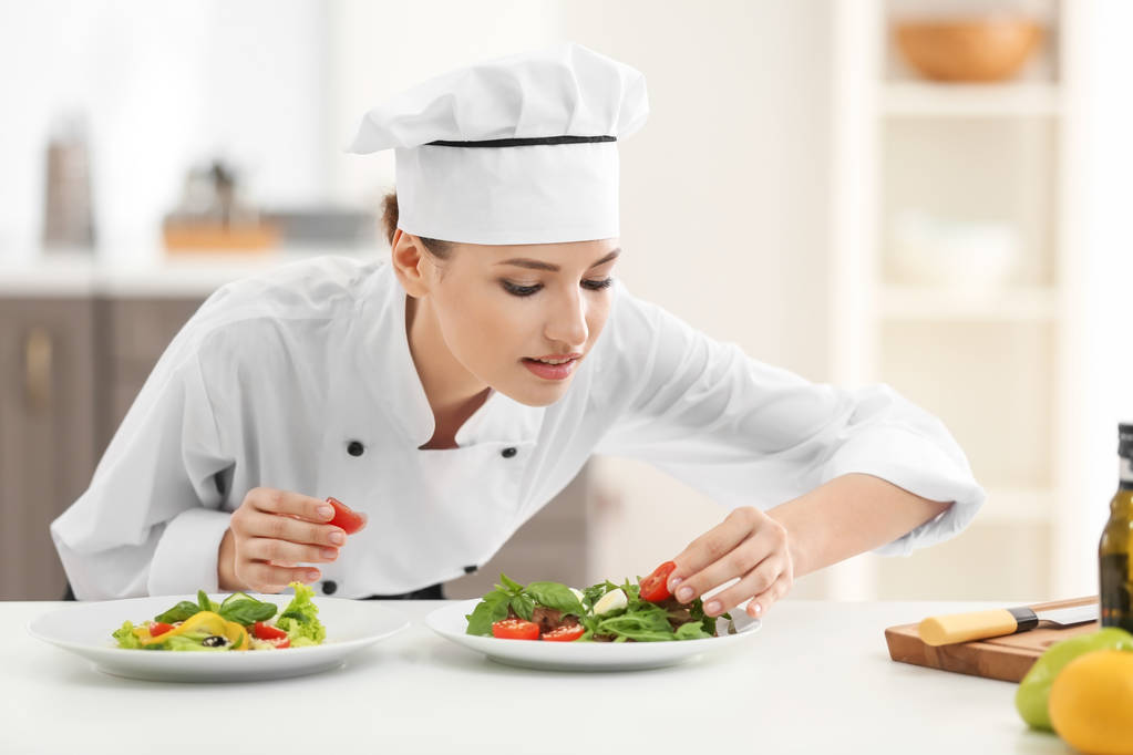 Jovem chef feminino com pratos saborosos na cozinha
 - Foto, Imagem
