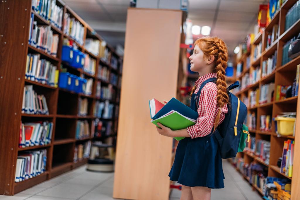 redhead schoolgirl in library - Photo, Image