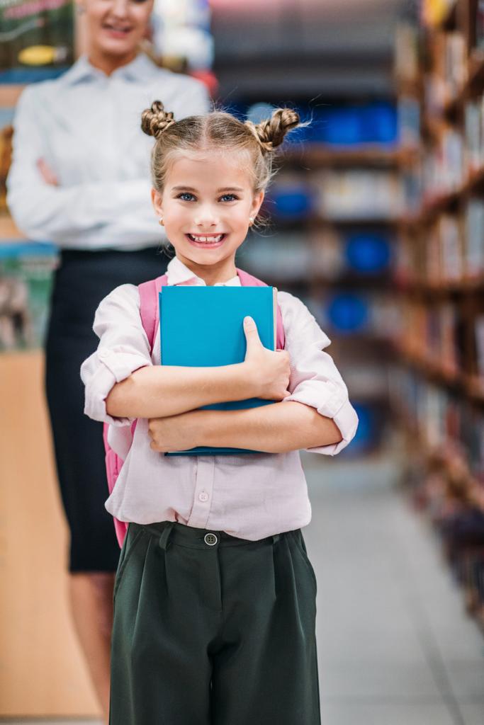 junges Mädchen in Bibliothek mit Lehrer - Foto, Bild