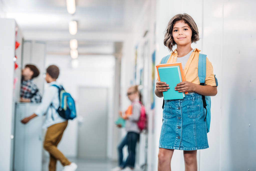 schoolgirl with books in corridor - Photo, Image