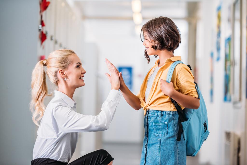 teacher giving high five to schoolgirl - Photo, Image