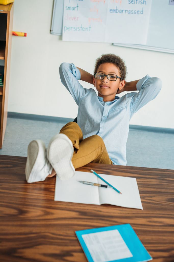 школьник сидит с ногами на столе
 - Фото, изображение