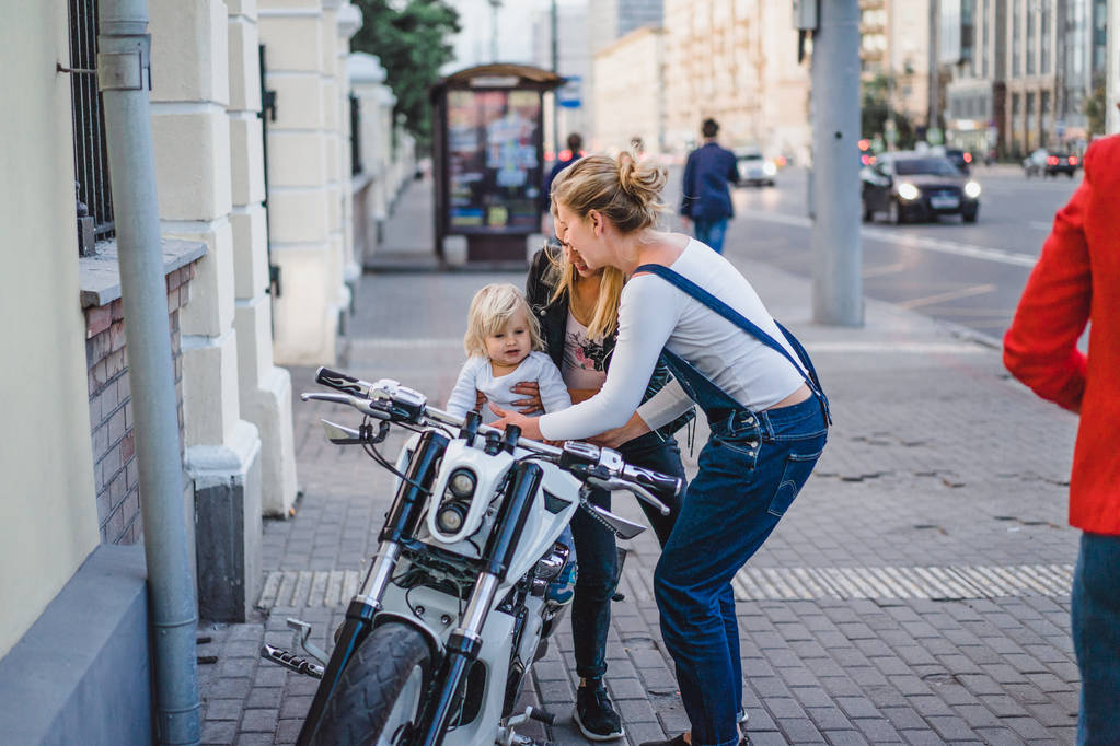 donne che si divertono con bambino ragazzo in moto
 - Foto, immagini