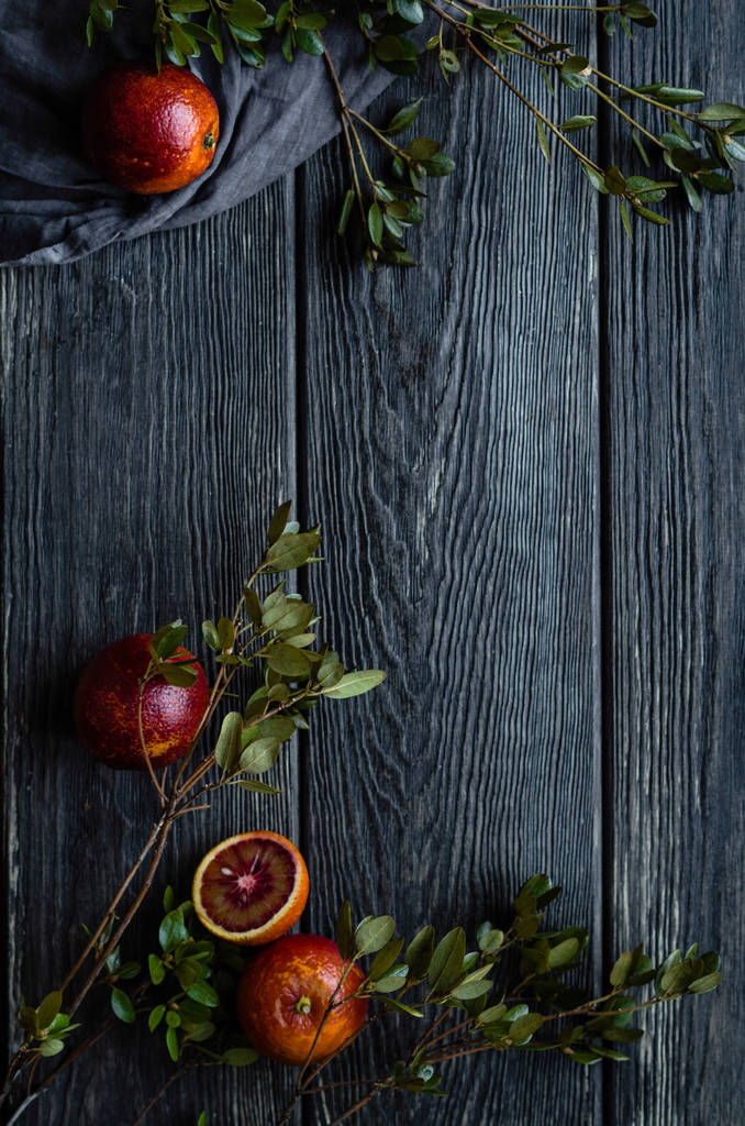 Krvavých pomerančů s listy na dřevěný stůl - Fotografie, Obrázek