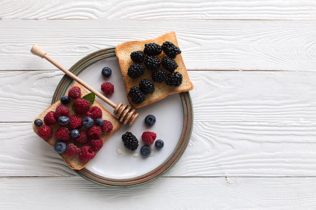 breakfast with berries on toasts and honey  - Photo, Image