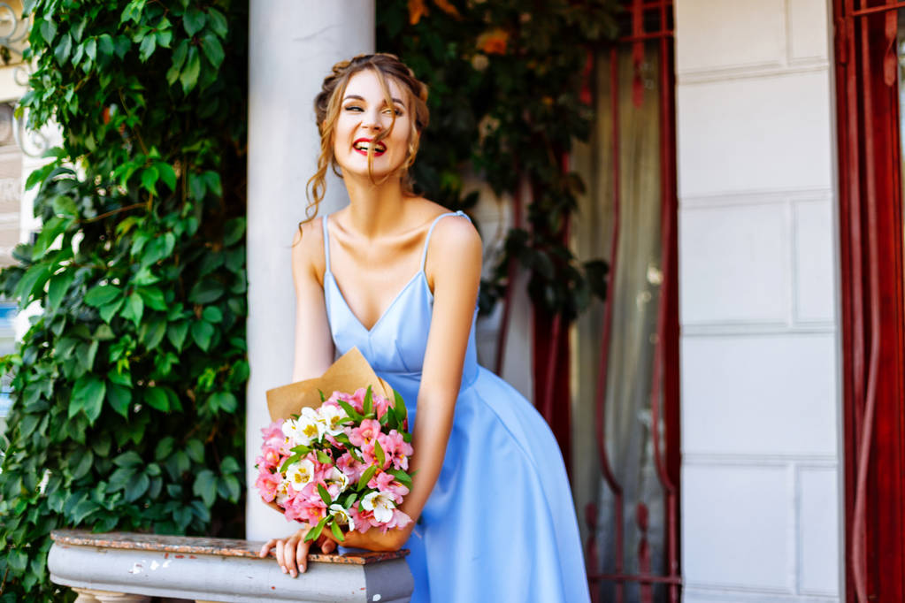 fille dans une robe bleue avec un bouquet debout près de colonne blanche
 - Photo, image