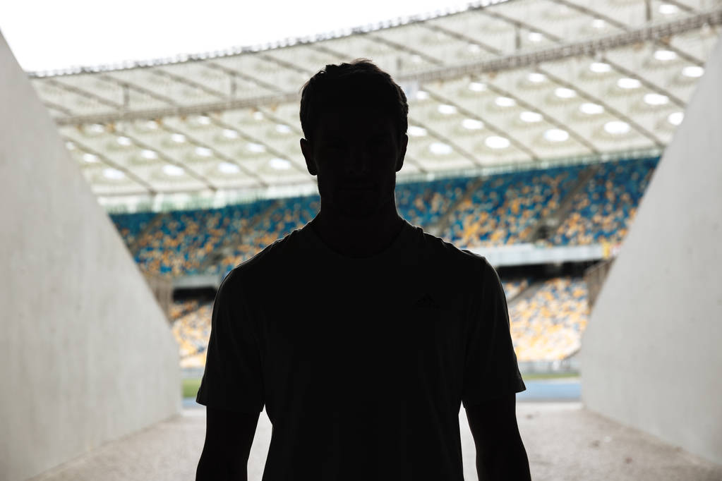 Silhouette eines Mannes, der am Stadion steht - Foto, Bild
