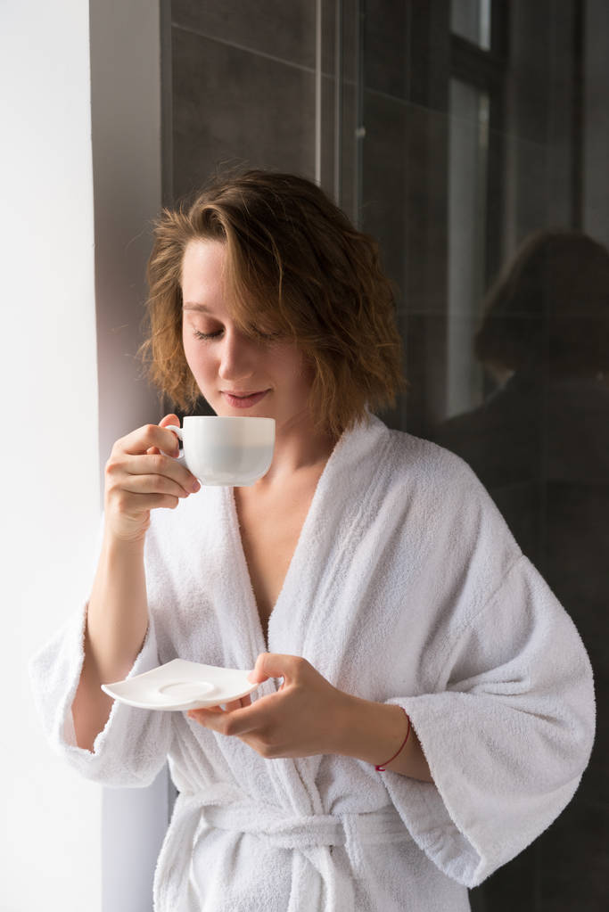дівчина в халаті п'є каву
 - Фото, зображення