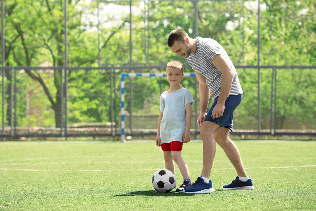 Отец и сын играют в футбол   - Фото, изображение