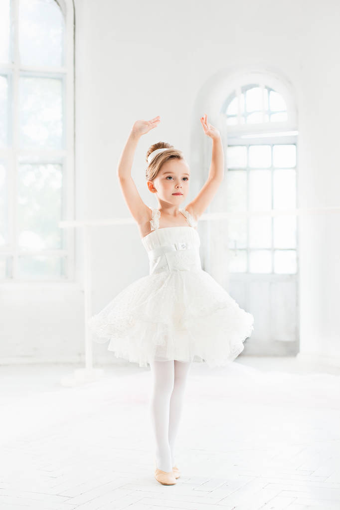 Pequeña bailarina en un tutú. Adorable ballet clásico de danza infantil en un estudio blanco
. - Foto, Imagen