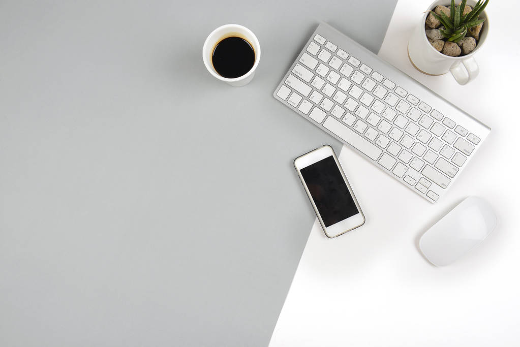 Biuro tabeli z klawiatury, myszy i smartphone na nowoczesne tło w dwóch odcieniach (biały i szary). - Zdjęcie, obraz