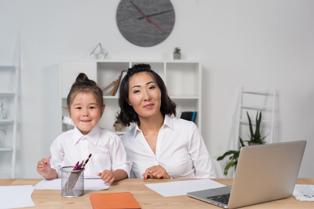 азиатская деловая женщина с дочерью в офисе
 - Фото, изображение