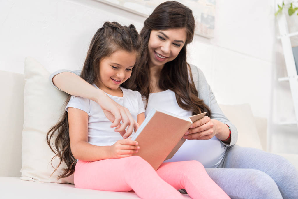 kislány, anya könyvet olvas - Fotó, kép