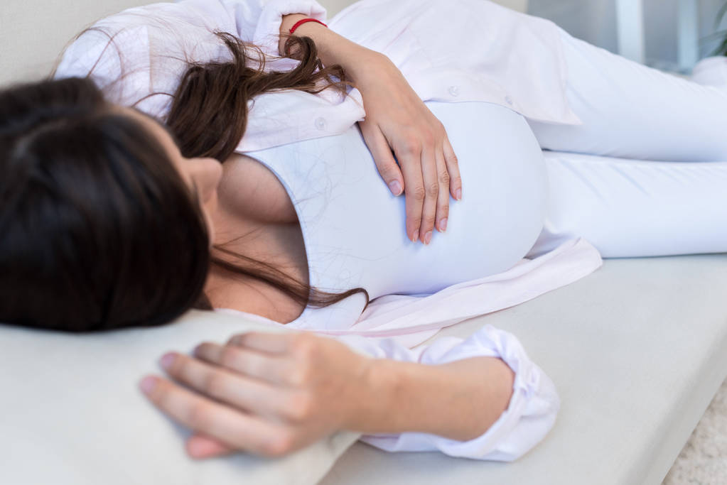 Mulher grávida deitada no sofá
 - Foto, Imagem