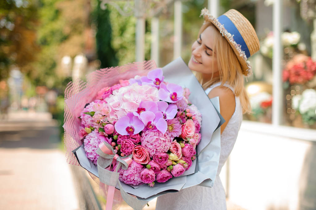 wunderschöner gemischter Blumenstrauß, der von einer lächelnden Frau gehalten wird. Selektiver Fokus - Foto, Bild