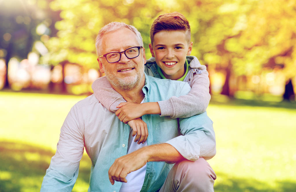 opa en kleinzoon knuffelen in zomer park - Foto, afbeelding