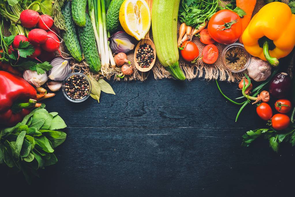 Keret bioélelmiszerek. Friss nyers zöldségek és fűszerek. A fából készült chalkboard. - Fotó, kép
