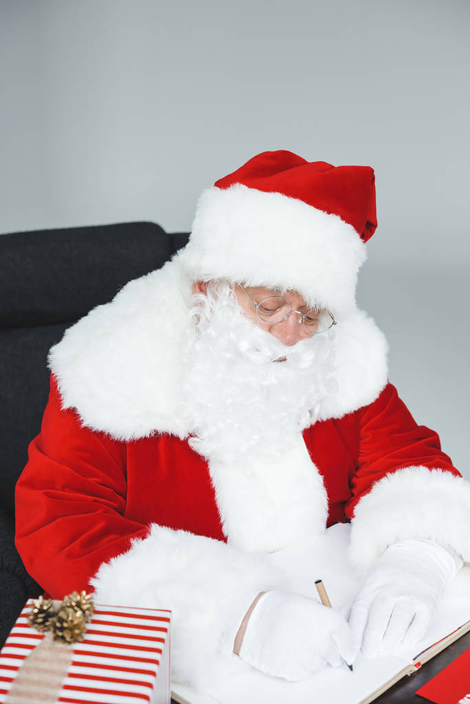 Kerstman zit in fauteuil - Foto, afbeelding
