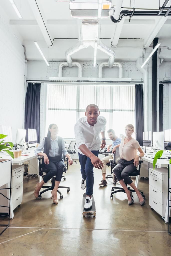 Uomo d'affari sullo skateboard in ufficio
  - Foto, immagini