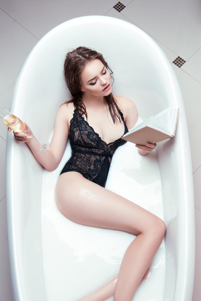 nainen lasi samppanjaa ja kirja kylvyssä
 - Valokuva, kuva