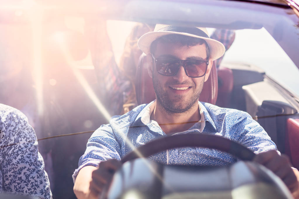 Grupo de alegres jóvenes amigos conduciendo coche y sonriendo en verano
 - Foto, Imagen