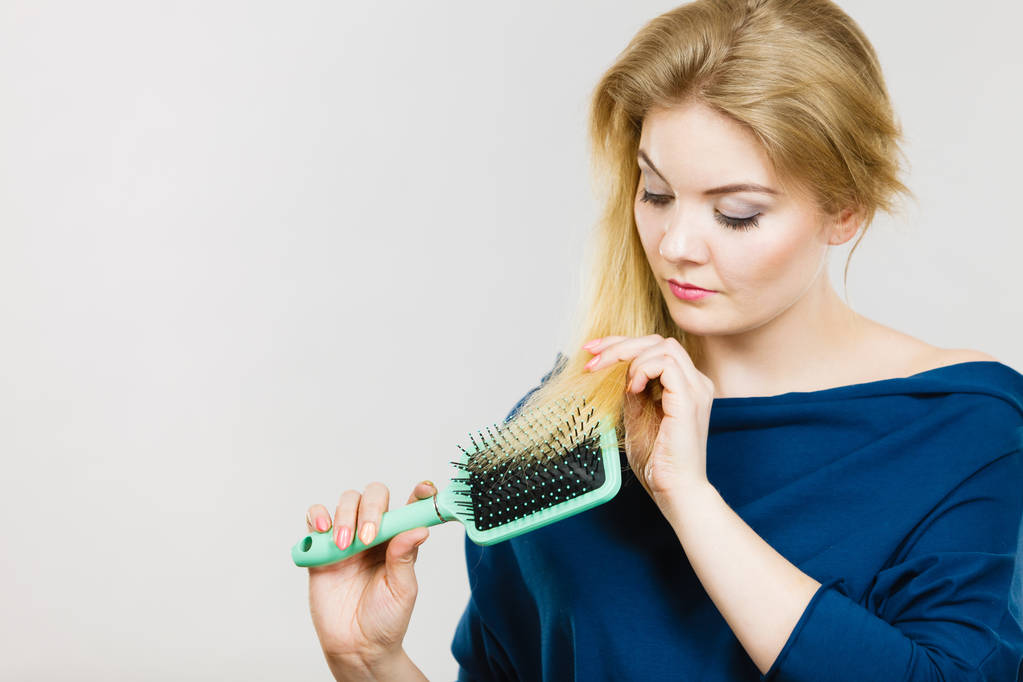 Mujer cepillándose el pelo largo con cepillo
 - Foto, Imagen